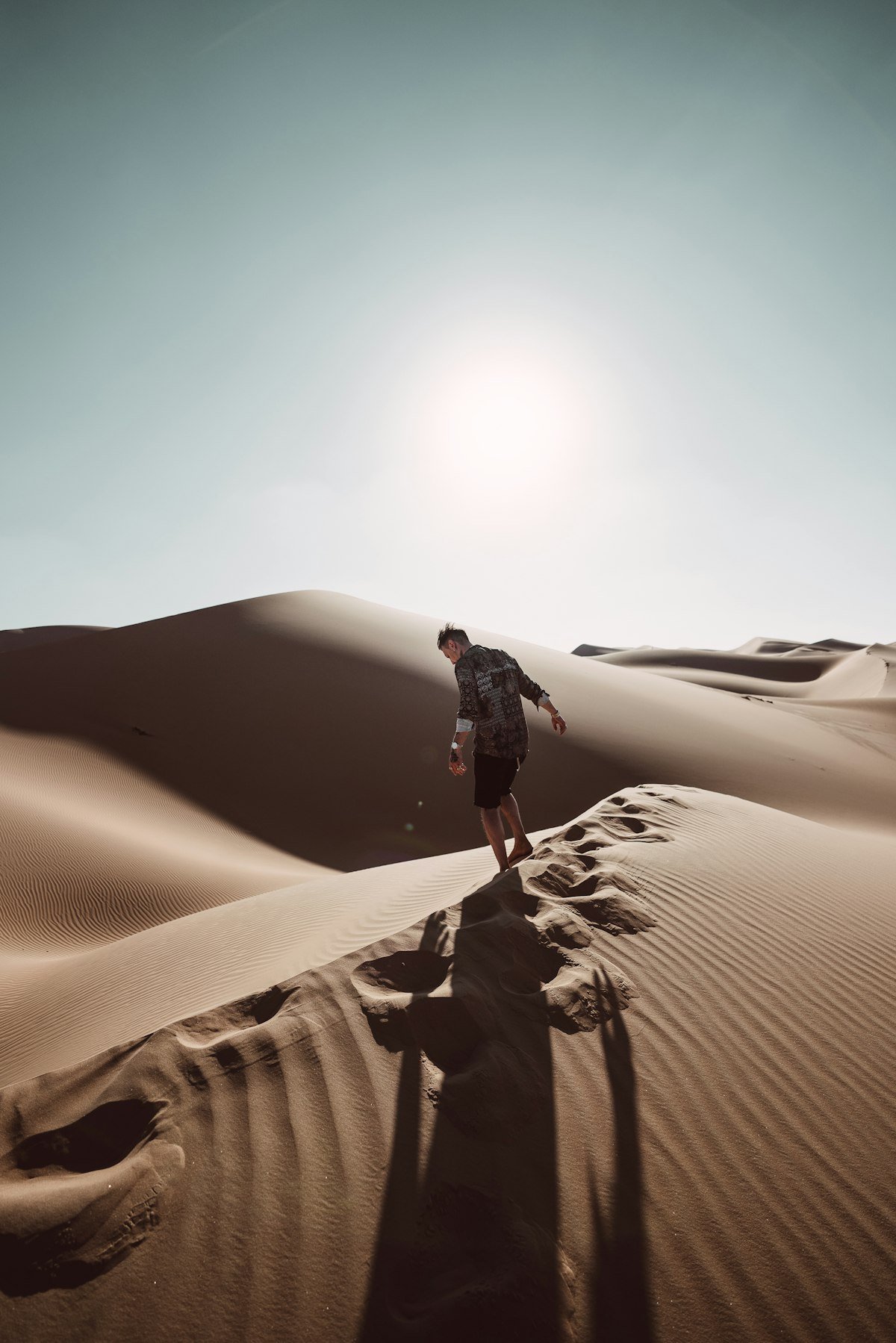 Traveller walking across golden desert dunes near Abu Dhabi
